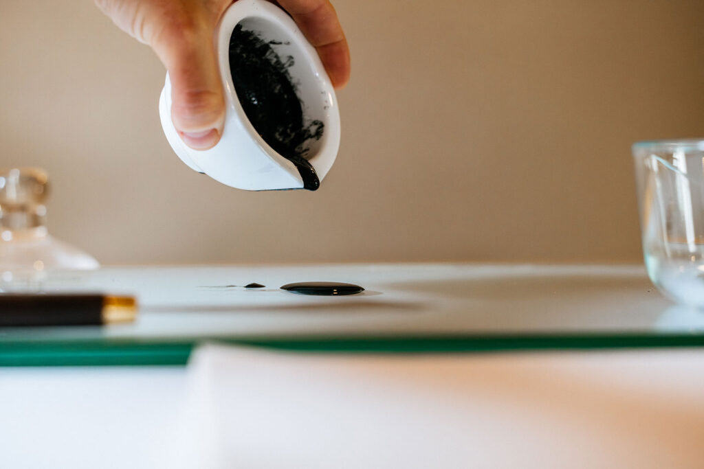 Pouring handmade wildfire ash ink onto a glass palette