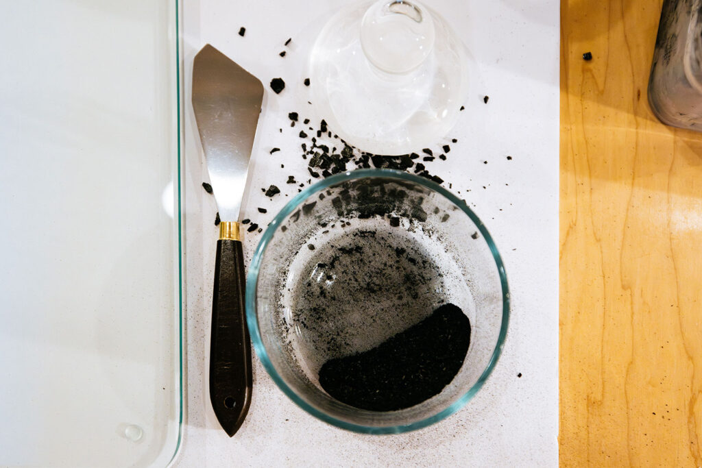 Refined wildfire ash pigment beside printmaking tools