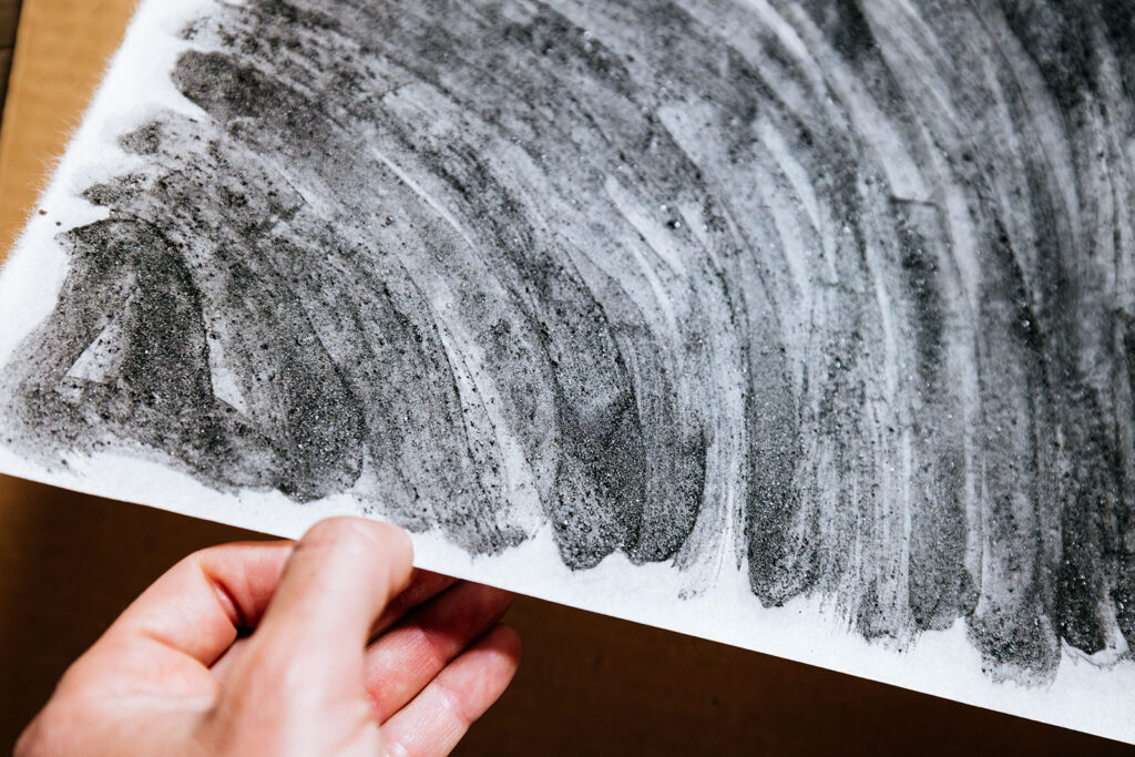 Wildfire ash pigment applied to textured paper surface